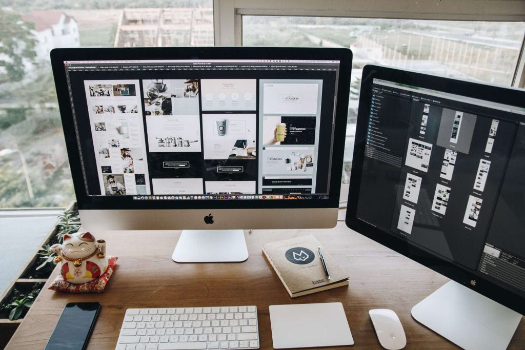 Website designs displayed on the screens
