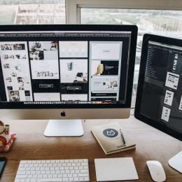 Website designs displayed on the screens